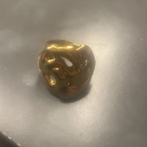 Chunky guldpläterad statementring - Cool statementring i chunky modell från Pilgrim med organiskt, skulpturalt formspråk. Ringen är guldpläterad och rostfri 