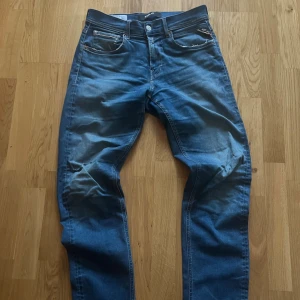 Blå Replay Grover Hyperflex jeans  - Jeansen är storlek W30 L32. Dom är relativt använda som syns på bilderna. Dom har slitning på ena knät och lappen på baksidan är lös om ni vill ha mer information eller bilder är det bara att fråga.