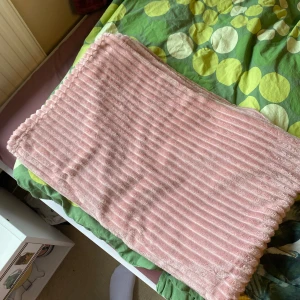 Pläd rosa - Filten har mestadels bara legat vid soffan utan att den används. 100% polyester, väldigt mjukt och mysigt material