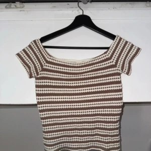 Randig brun och vit topp från Nelly - Säljer en fin topp från Nelly som har används ett fåtal gånger men är i ett väldigt fint skick!