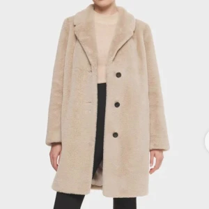 Rockandblue Diddi Coat Beige Strl 36 - Elegant kappa från Rock and Blue i beige fuskpäls, strl 36. Klassisk krage och knäppning framtill, sidofickor samt en innerficka med dragkedja.  100% polyester. Superdupermjuk, som den lenaste av teddybjörnar.  Aldrig använd. Nypris 2299kr.