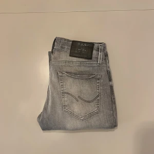 Grå slim jeans från Jack & Jones - Snygga grå jeans från Jack & Jones i modellen Slim Glenn. Jeansen har en slim passform, klassisk femficksdesign och cool tvättad look. Perfekta för dig som gillar en smalare siluett och vill ha ett par stilrena jeans i garderoben. De är lite kortare i storleken om vi undrar hur de sitter!