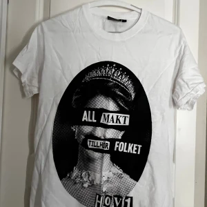 Vit t-shirt Hov1 med tryck, strl S - Vit t-shirt från Hov1 i 100% bomull med svart grafiskt tryck framtill. Lite nopprig i armhålorna men inget som syns. Köpt från webbshoppen för nått år sedan. Använt fåtal gånger. Katter finns hemma 
