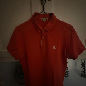 Röd/orange pike från burberry. - Röd pike från burberry i storlek S. motsvarar ungefär om du är mellan 170-180 men beror lite på din vikt. Tröjan köptes för runt 2000kr ny. 