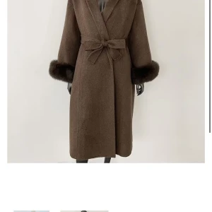 Brun kappa med pälsdetaljer och bälte - Säljer en brun kappa med fluffiga äkta pälsdetaljer vid ärmsluten som är avtagbara och ett snyggt bälte i midjan. Fick den i födelsedagspresent men tycker den är lite för ”oversized” för min smak så vill gå ner i storlek. 90% ull och 10% kashmir. Aldrig använt, testat hemma bara 2-3 ggr
