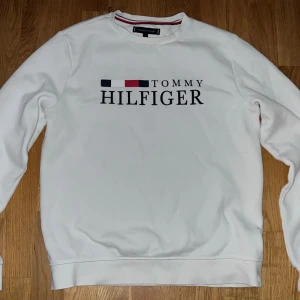Vit sweatshirt Tommy Hilfiger S - Vit sweatshirt från Tommy Hilfiger i storlek S. Knappt använd och i väldigt bra skick. En liten defekt som ni ser på bilden men den är ändå perfekt för en clean och stilren look.