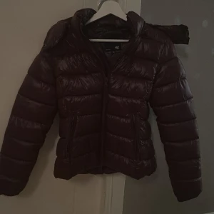 Vinröd pufferjacka från lager 157 - ‼️säljer även en marinblå‼️Säljer en vinröd pufferjacka från 157 i storlek xs med glansig finish och avtagbar huva. Jackan har dragkedja framtill och två snedställda fickor med dragkedja. Perfekt för kalla dagar och har en modern passform. Den ser lite brun ut på bilden men den är vinröd💕 använd endast ett par gånger. Köpt för 400kr