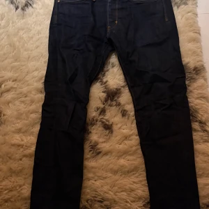 Mörkblå jeans från Neuw - Snygga mörkblå jeans från Neuw med klassisk femficksdesign och kontrastsömmar. Modellen har rak passform och normal midja, tillverkade i slitstarkt denim med kopparfärgade nitar och knapp. Perfekt för dig som gillar stilrena och tidlösa jeans.