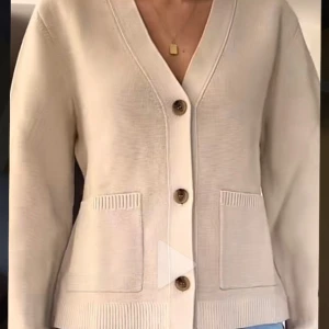 Beige kofta från Arket med fickor - Snygg beige kofta från Arket med v-ringning och tre knappar framtill. Koftan har två stora fickor och ribbade detaljer vid ärmslut och nederkant. Perfekt att slänga över en t-shirt för en chill look. Materialet är mjukt och stickat.