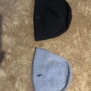 Två mössor från Polo Ralph Lauren - Säljer två klassiska mössor från Polo Ralph Lauren, en i svart och en i ljusgråt. Jag säljer en för 249kr och bådda två för 400kr. Kom privat för info!