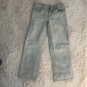Ljusblå raka jeans från ONLY - Säljer ett par ljusblå jeans från ONLY i rak modell. Jeansen har klassisk femficksdesign, bälteshällor och knappgylf. Perfekta för dig som gillar en enkel och stilren look. Materialet är jeans i bomullskvalitet.sytt lite under gylfen men man ser knappt när man har på sig dom.