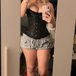 Svart korsett  XS - Säljer en svart korsett i storlek XS med subtilt blommönster. Toppen har snörning framtill, där bak knyter man som vilken korsett som helst perfekt nu för hallween!🩷finns ett litet håll dock men syns inte❤️