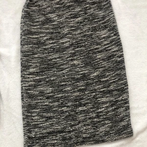 Gråmelerad stickad långkjol - Snygg gråmelerad stickad långkjol med rak passform. Kjolen har en mjuk och bekväm känsla, perfekt för dig som gillar en stilren och enkel look. Den melerade färgen ger en cool och avslappnad vibe.