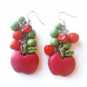 Färgglada örhängen med äppeldetaljer - Unika örhängen med stora röda äpplen i polymerlera, dekorerade med gröna och röda pärlor samt små blad. Hängande modell med silvriga krokar, perfekt för dig som vill sticka ut med ett lekfullt och färgstarkt smycke. ALLERGIVÄNLIGT ❤️