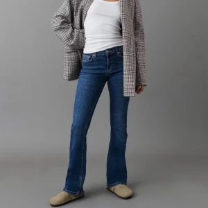 bootcut jeans blå - Snygga gina tricot i klassisk blå denim med bootcut passform. Jeansen har fem fickor, normal midja och raka ben som slutar i en lätt utsvängning. Perfekta för dig som gillar en tidlös och avslappnad stil.