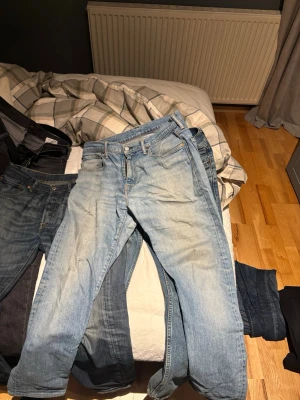 Levi's 502 ljusblå jeans W32 L34 - Säljer ett par Levi's 502 jeans i ljusblå tvätt med klassisk femficksdesign och raka ben. Jeansen har en snygg slitning och är tillverkade i bomull med Levi's ikoniska läderpatch bak i midjan. Perfekt för dig som gillar en avslappnad och tidlös stil.