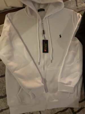 Ralph Lauren - Säljer en helt ny Vit Ralph Lauren som är i storlek M, håller dig stilig och varm, om du vill köpa den svarta så finns det i min profil och om du vill köpa båda så får du dem för 900kr tsm. Är det något du undrar över skriv direkt..Passa på och köp❄️