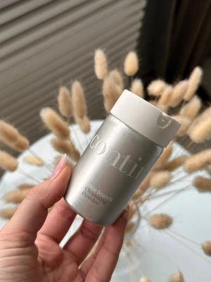 Continu Cleansing Powder - Risstärkelse-rengöringspulver (som torrschampo) från Continu i en stilren metallisk burk med vit lock. Pulvret doseras enkelt i håret genom hålen i locket. 