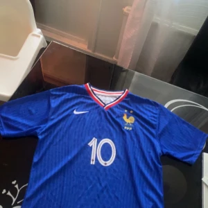 Kylian Mbappe tröja (FFF) - Hej. Säljer min kylian mbappe tröja. Tröjan är blå och representerar Frankrike herrlandslag. Kvaliten är väldigt bra och storleken på den är L fast passar folk med M och Xl. Prisjustering kan diskuteras.