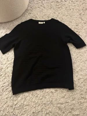  KappAhl - En enkel svart stickad T-shirt från KappAhl i storlek m