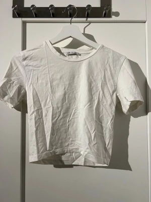 Vit basic t-shirt från Zara - Enkel och stilren vit t-shirt från Zara i storlek S. Modellen är kortärmad med rund halsringning och tillverkad i mjuk bomull.  