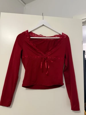 Röd tröja med spets  - En röd tröja med spets och band.