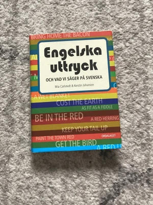 Engelska uttryck och vad vi säger på svenska - Upptäck roliga och användbara engelska uttryck och deras svenska motsvarigheter! Perfekt för dig som vill briljera med språket, förstå memes och snacka som en native. Boken är färgglad och lättläst, fylld med tips och översättningar som gör engelskan roligare och enklare.