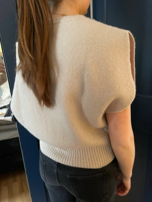 Beige stickad ärmlös tröja från Zara - Veige stickad tröja från Zara🤎 Tröjan är typ ärmlös med breda axlar och har en ribbad kant vid halsringning och nederkant.  Köpt för 499 och använd ca 2 gånger så i nyskick! 