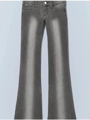 Grå bootcut jeans med blekta detaljer - Snygga grå jeans med bootcut passform och blekta detaljer längs benen. Klassisk femficksmodell med knapp och dragkedja framtill. Perfekta för dig som gillar en retro vibe och vill sticka ut lite extra. Materialet är mjukt och stretchigt jeans. Obs gröna detaljen på baksidan är bortklippt.