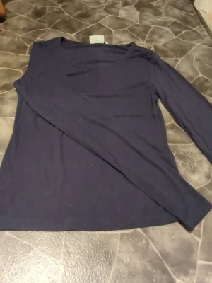 Mörkblå långärmad topp från Kappahl - Säljer en enkel och stilren mörkblå långärmad topp från Kappahl i storlek S. Toppen har rund halsringning och är gjord i mjukt bomullsmaterial, 