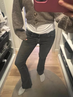 Bootcut svarta jeans med låg midja - Svarta bootcut jeans med låg midja. Jeansen har en snygg tvättad look och är tillverkadee i ett stretchigt jeansmaterial som sitter skönt. Passformen är normal och benen är utsvängda nedtill. Storlek 158/164 passar xs/s som är cirka 155-165 cm. Pris kan diskuteras💕