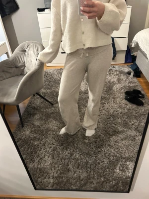 Beiga mjukisbyxor från Gina Tricot - Säljer ett par beiga mjukisbyxor från Gina Tricot i storlek 170 med bred resår i midjan och snörning framtill. Byxorna har raka ben och är i superbra skick.