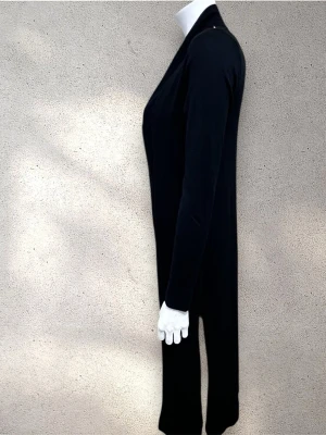 Lindex lång cardigan - Svart lång cardigan med stilren design och lång ärm. Perfekt för lager-på-lager och enkel att matcha med olika outfits. #lindex #cardigan #koftor