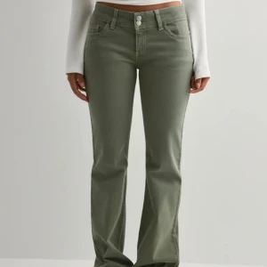 Gröna bootcut byxor med hög midja - Snygga gröna byxor med bootcut-silhuett och hög midja. Byxorna har klassisk femficksdesign, dubbla knappar i midjan och raka ben som släpper ut vid ankeln. Perfekta för en trendig och avslappnad look. Använda enstaka gånger.