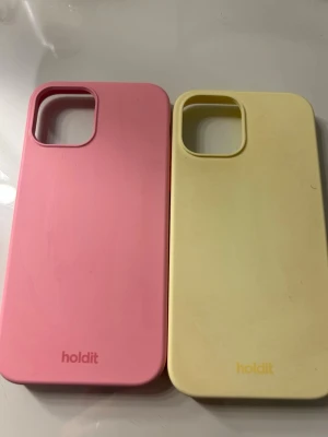 iPhone 12 skal från holdit, gult och rosa - Två iPhone 12 skal från holdit som knappast används och passar inte modellen jag har nu. Dom båda är i super fint skick och inget som är söndrigt eller förstört! 