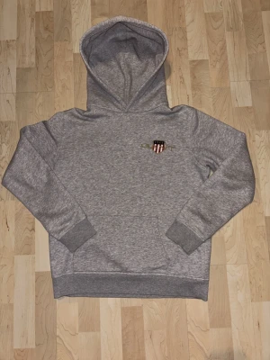 GANT Hoodie - Säljer en grå GANT hoodie! Hoodien passar S men fungerar också bra för folk med M. Hoodien är i bra skick och har inga defekter! Skriv vid ytterligare frågor eller bud!