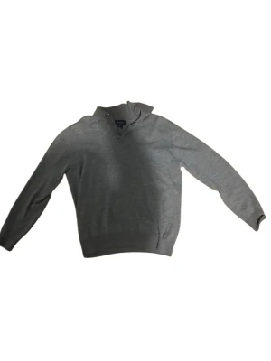 Grå merinoull pikétröja Paul Fredrick - Snygg grå pikétröja från Paul Fredrick i 100% merinoull. Tröjan har klassisk krage, v-ringad öppning med knapp och långärmad design. Perfekt för dig som gillar stilrena och bekväma plagg med lite extra premiumkänsla. Nypris Ca 1500 kr