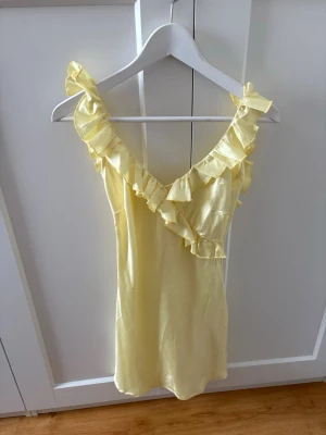 Klänning - Super fin gul satinklänning med oppen rygg och volanger från Shein i storlek xs