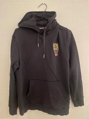 Mörk blå Morris hoodie - Säljer en schysst hoodie från morris. Hoodien är i  bra skick utan några stora defekter. Nypris ca 2000kr. Storlek L men sitter mer som M