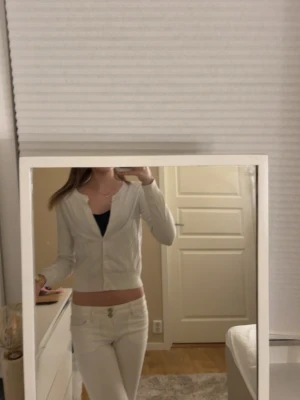 Vit kofta från H&M,  - Säljer en enkel och stilren vit kofta från H&M i storlek XS. Koftan har långa ärmar, knappar framtill och är gjord i mjukt bomullsmaterial. Perfekt att slänga över en topp för en clean look.