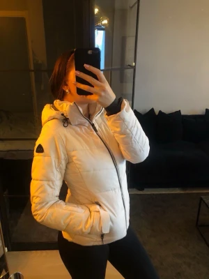 BBL jacka med huva - Säljer en snygg vit McKinley jacka med huva och svarta dragkedjor. Jackan har en ”kvinnlig” passform vilket gör att man får ett kurvigare utseende vilket är jätte snyggt!Jackan har två fickor med dragkedja och märket på ärmen. Nypris ca 1300