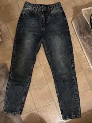 Mörkblå high waist jeans  - Säljer ett par mörkblå jeans från Trendyol med snygg tvättad look och klassisk femficksdesign. Byxorna har hög midja och raka ben med en lite loose passform. Perfekta för dig som gillar en avslappnad men ändå stilren vibe.