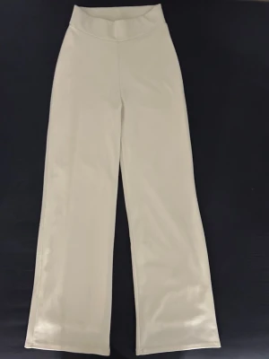 Vida vita byxor från NLY Trend XS - Snygga vida byxor från NLY Trend i storlek XS. Byxorna är vita med hög midja och raka, breda ben. De är hyfsat stretchiga och i ett lite glansigt/skimrande tyg. Ganska tunna och liknar typ mjukisbyxor. Säljer eftersom de inte kommer till användning men jättefint skick💗