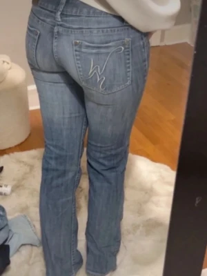 Replay ljusblå bootcut jeans - Säljer ett par ljusblå Replay jeans med bootcut. Jeansen har låg midja och snygga slitningar. Materialet är mjukt jeans-tyg i bomull och de har en broderad detalj på bakfickan. Passar om du är runt 160-165cm. Innebenslängden 78cm och midjan 34cm.