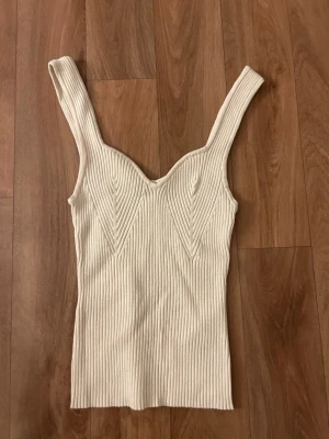Ribbad beige linnetopp Gina Tricot - Säljer en ribbad beige linnetopp från Gina Tricot i storlek XS. Toppen har breda axelband och passar till alla outfits, super fin till sommaren. Endast använt 1 gång 