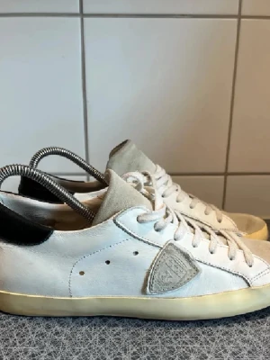 Vita Philippe Model sneakers  - Säljer ett par vita Philippe Model sneakers med beige mockadetaljer på tån och plösen. Använda få gånger. Nypris ca 3299kr. Bara att höra av sig vid frågor och funderingar!