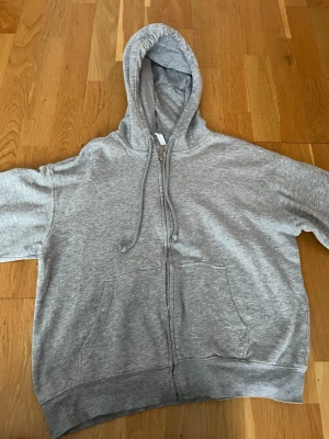 Zip hoodie - Det här är en grå zip hoodie som har luva med band 