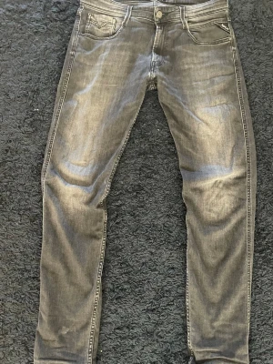 Replay jeans  - Snygga svarta jeans från Replay med klassisk femficksdesign och diskreta slitningar. Jeansen har en slim passform och raka ben, med Replay-logga på bakfickan och läderpatch i midjan. Storlek 32 32 