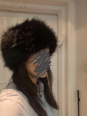 Svart pälsmössa - Fluffig och snygg svart pälsmössa / pälshatt från Tamsons. Klassisk rundad form i mjuk pälsimitation som ger en lyxig känsla. Nyskick!