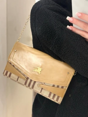 Burberry handväska - En jätte fin burberry handväska. Den har bra och rymlig plats! Skitsnygg till sommaren! Fått i present för ett tag sedan, använder inte väskor, så vill bara få bort den till någon som har nytta av den🥰